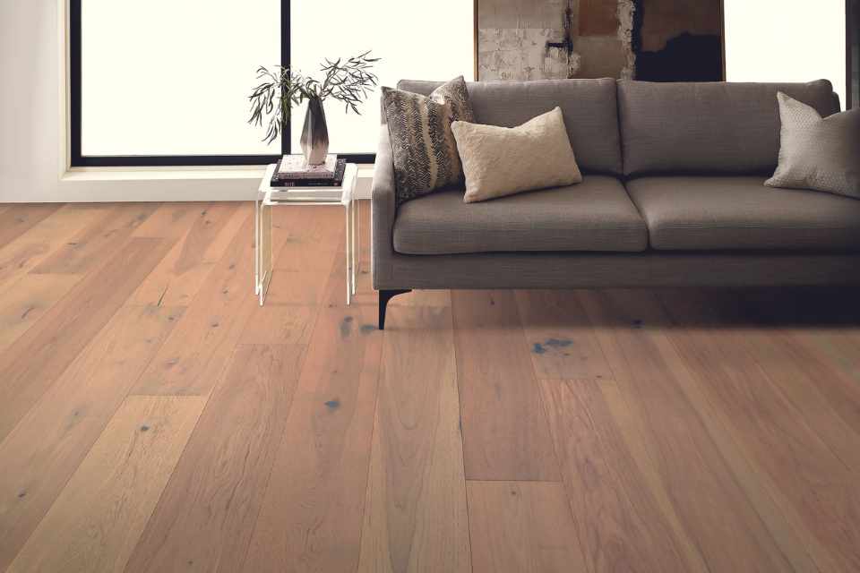 engineered hardwood flooring in modern industrial living room with grey couch and greenery